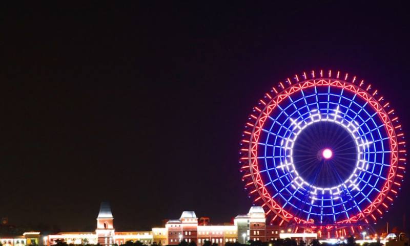 麗寶樂園渡假區2日起推出國慶限定燈光秀，園區天空之夢摩天輪結合紅、藍、白光束，在空中化作巨大光影畫布，閃耀10月夜空。（麗寶樂園提供）