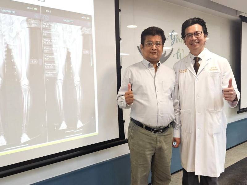 61歲的藍先生（左）因骨折宿疾導致膝關節變形，經台北醫學大學附設醫院骨科部主治醫師吳家麟（右）以新式膝關節保留手術治療後，找回健走人生。 （台北醫學大學附設醫院提供）