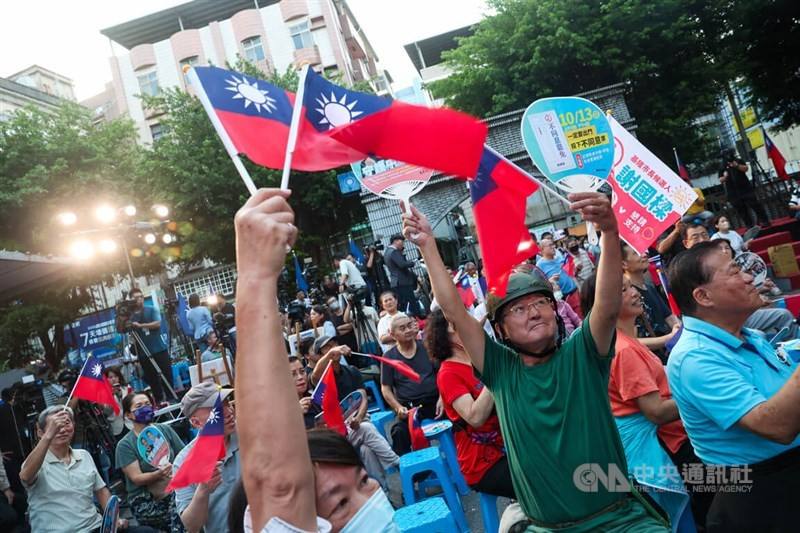 Supporters of Keelung Mayor Hsieh Kuo-liang wave flags in front of the Kuomintang party headquarters of Keelung City to show support on Sunday.