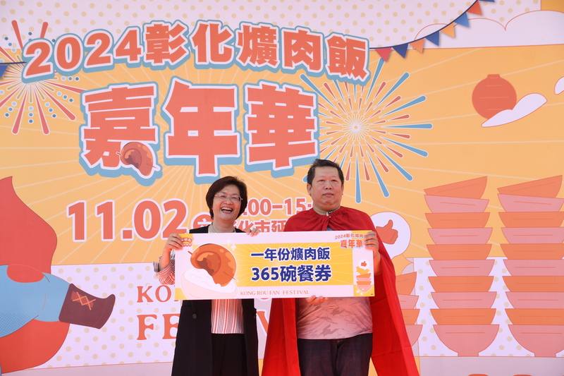 2024彰化爌肉飯嘉年華2日在彰化市延平公園登場，縣長王惠美（左）會中頒獎本屆「爌世英雄」姚姓男子（右），獎品是1年份共365碗的爌肉飯餐券