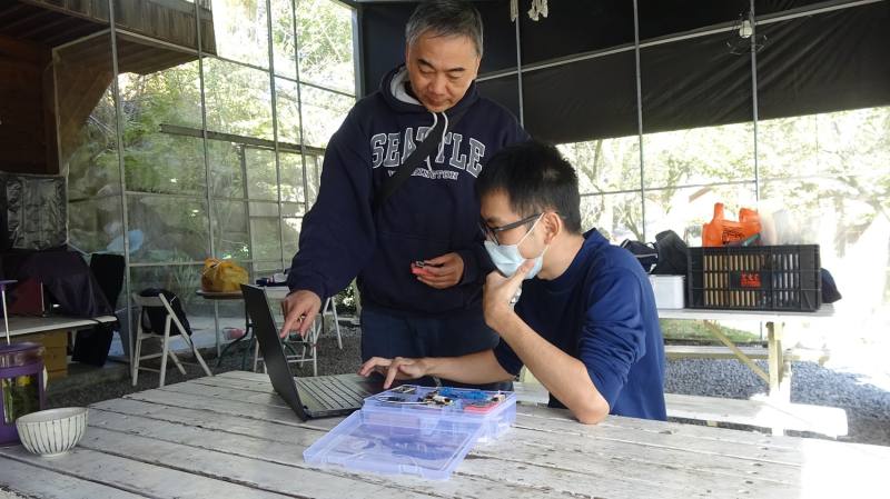 林宗宏教授與學生架設電腦及網路，再由大學生教導小朋友使用學習