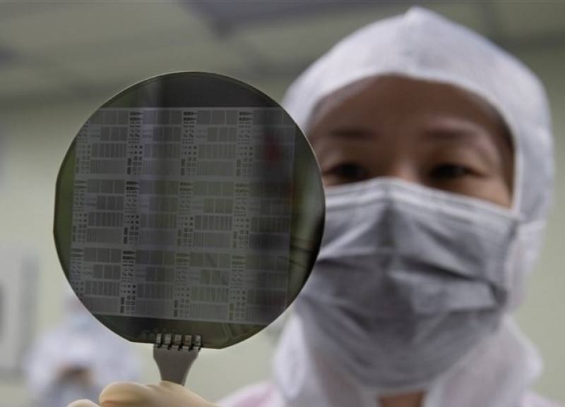 A technician examines a silicon wafer.