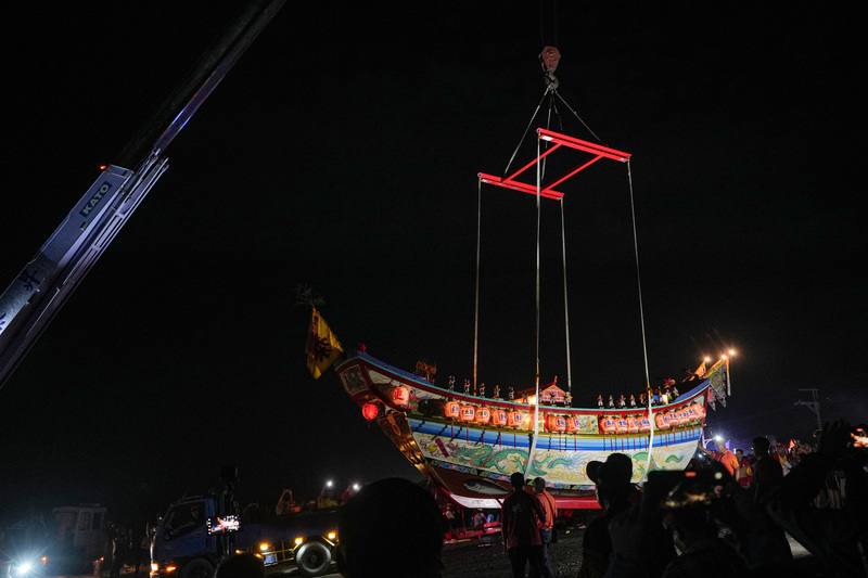 屏東3大迎王平安祭典壓軸場南州迎王，18日凌晨在林邊鄉崎峰海灘舉行送王儀式。圖為王船拖運至崎峰海灘後，由吊車吊運至更靠海的定位。