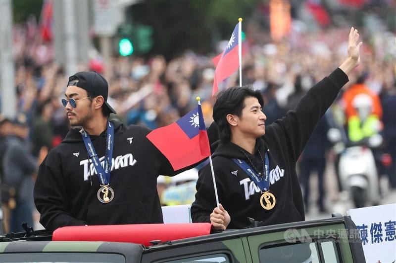 Team captain Chen Chieh-hsien (right) and catcher Lin Chia-cheng wave to fans while holding Republic of China (Taiwan) flags. CNA photo