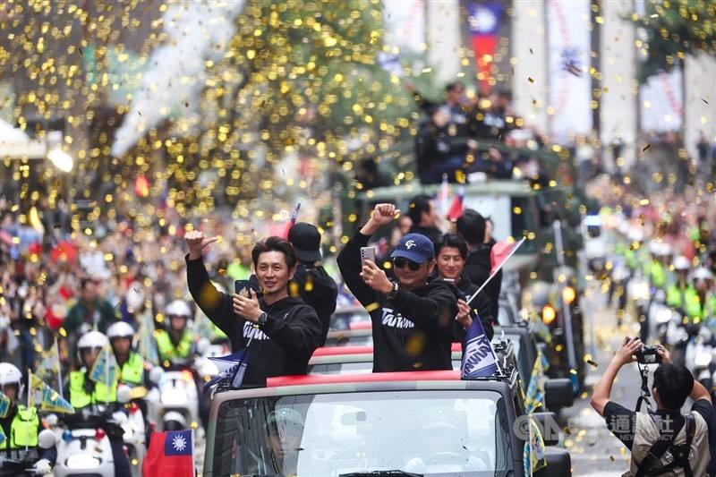 Taiwan's baseball manager Tseng Hao-jiu (right) and coach Kao Chih-kang give a thumbs up to the crowd during the parade. CNA photo