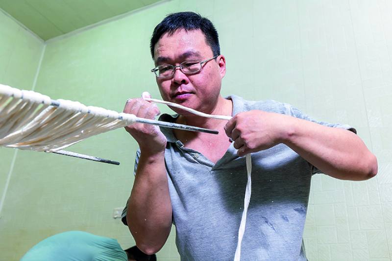 Pan Jianzhong demonstrates “hanging” the noodles, which involves twirling and rolling the dough. His speed and dexterity are riveting.