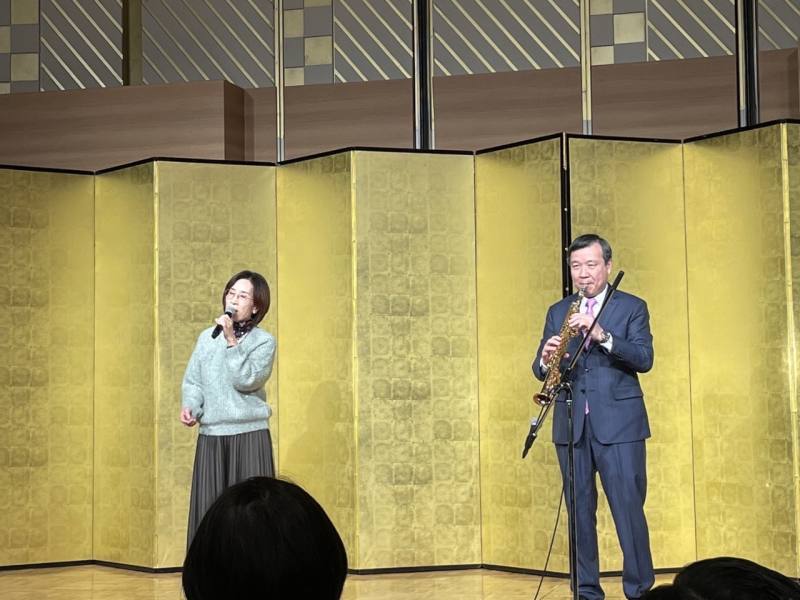 北駐日經濟文化代表處24日晚間舉辦忘年會，席間駐日大使李逸洋演奏薩克斯風、並在夫人的歌聲下，一起「雙劍合璧」合演經典台語名曲《深情海岸》。（鄭仲嵐提供）