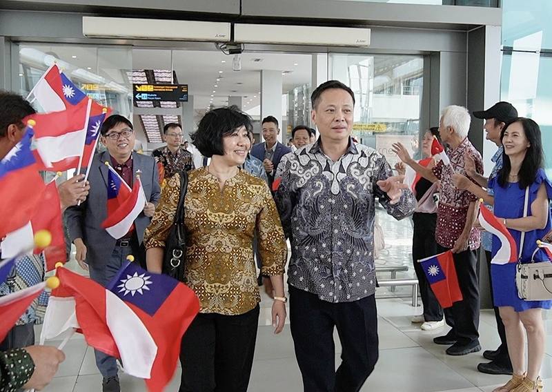 印尼台僑27日在蘇卡諾哈達國際機場揮舞國旗，歡迎駐印尼代表洪振榮（右前）伉儷抵達