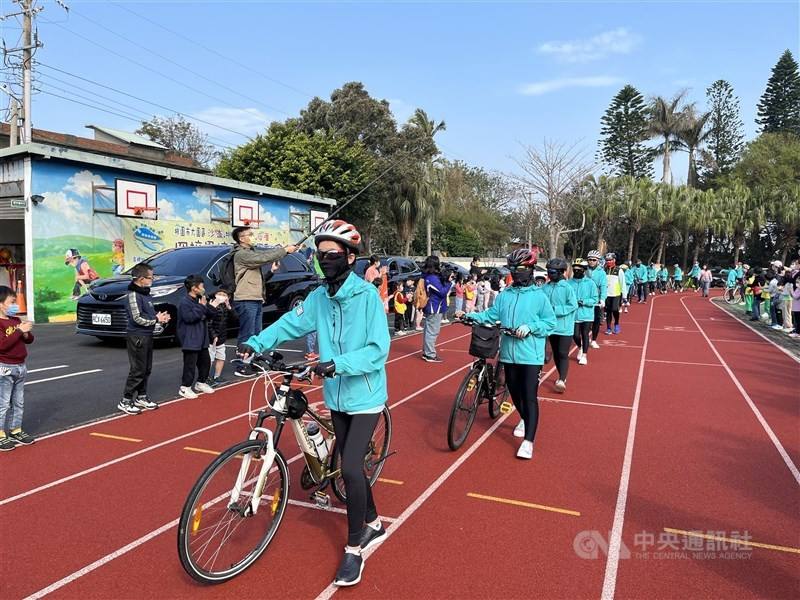 The last group of students to graduate from Hou Tsuo Elementary School in Taoyuan's Dayuan District forms a line on campus for a send-off before embarking on a cycling graduation trip around Taiwan on March 9, 2023. The school was one of those closed for 