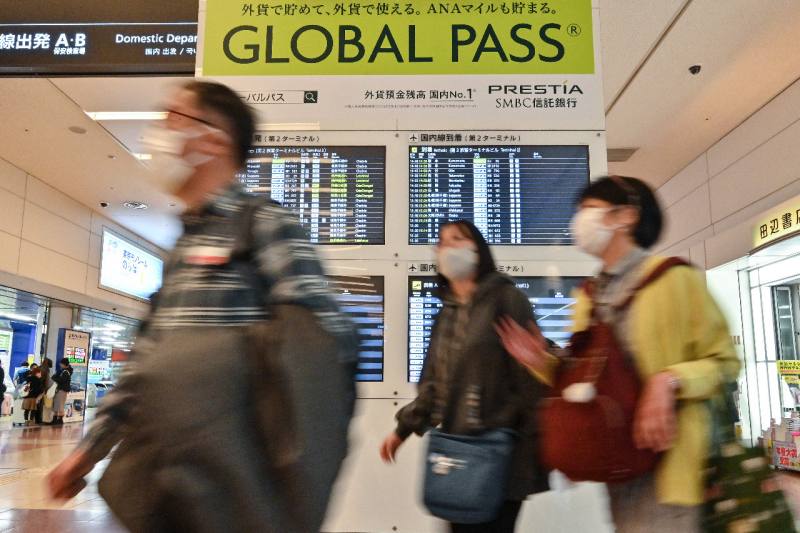 日本民眾結束新年假期，搭乘新幹線返回工作崗位時，不忘戴上口罩。(AFP)