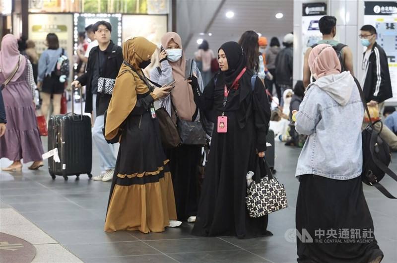 Female migrant workers spend a weekend together at the Taipei Main Station in this CNA file photo