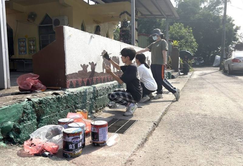 義守大學新媒體設計系師生走出校園，與屏東縣三地門鄉馬兒社區攜手啟動馬兒教會女兒牆美化工程。師生與族人以「瓦酪露信仰大道」為主題，創作壁畫。（義守大學提供）