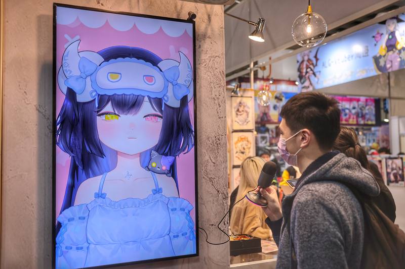 A visitor to the Taipei International Comics and Animation Festival interacts with a digital device on Thursday. CNA photo Feb. 6, 2025