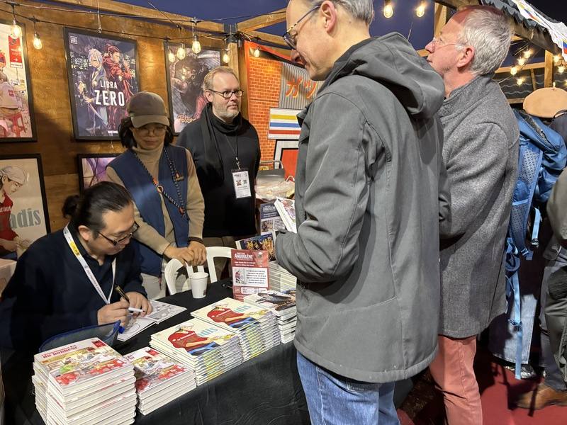 Taiwanese comic book artist Ruan Guang-min (left) signs for fans at the Angoulême International Comics Festival in France. CNA photo Feb. 4, 2025