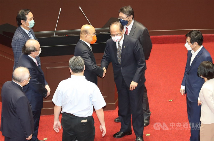 Premier Su Tseng-chang (in orange mask) shakes hand with Legislative Speaker You Si-kun on the floor after lawmakers passed the new round of COVID-19 relief package on Friday.
