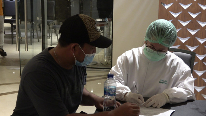 慈濟醫院印尼分院自4月起配合印尼政府施打疫苗計畫，目前每天可為超過2000人接種疫苗，圖為慈濟印尼分院醫護人員22日為民眾說明疫苗施打應注意事項。