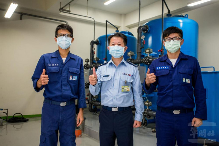 週檢中隊中隊長方玉龍中校在沖淋站控制室與所屬官兵合影。