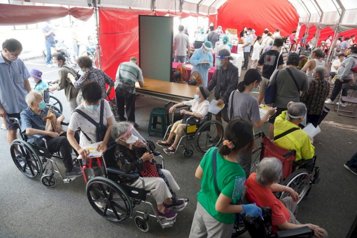 日本贈送的124萬劑AZ疫苗15日開放85歲以上長者施打。不少長輩在親人或看護的陪同下前往台北榮總排隊，等候接種疫苗。 (圖：中央社)