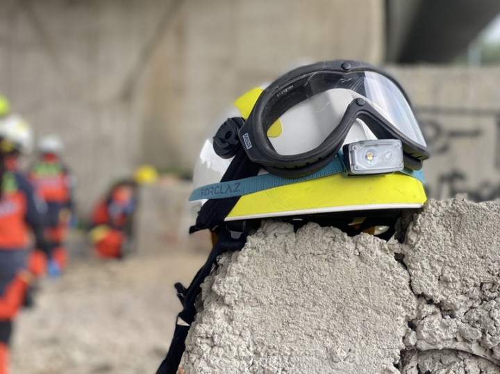 在分秒必爭的搜救現場，特搜醫師隨身裝備必須盡可能輕便，不但要訓練高空垂降，還得趴著幫傷患打點滴，他們除了醫人，也治療搜救犬。（台北慈濟醫師陳玉龍提供）