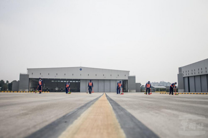 週檢中隊官兵在飛機駛入前執行FOD（外物損傷）的檢查動作。