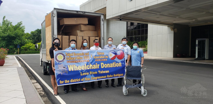 黃雅惠〈左3〉、李聰福〈左2〉、黃仲庭〈右2〉、李欣 芬〈左1〉、黃得富〈右1〉及丁秋仁〈右3〉等人將輪椅 移交給德查韋斯〈圖中〉。