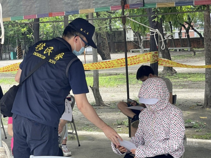 An immigration officers hands a paper form to a woman in Kaohsiung. Photo courtesy of the NIA's Kaohsiung service station