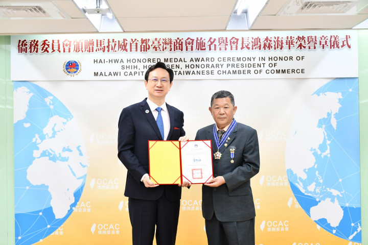 委員長童振源(左)頒發海華榮譽章予施鴻森(右)。(僑委會提供)