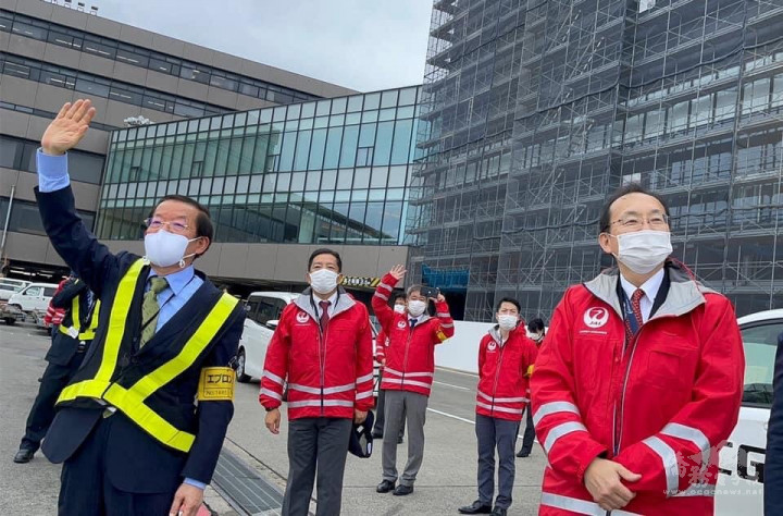 謝長廷與成田機場工作人員揮手送載著疫苗飛機起飛