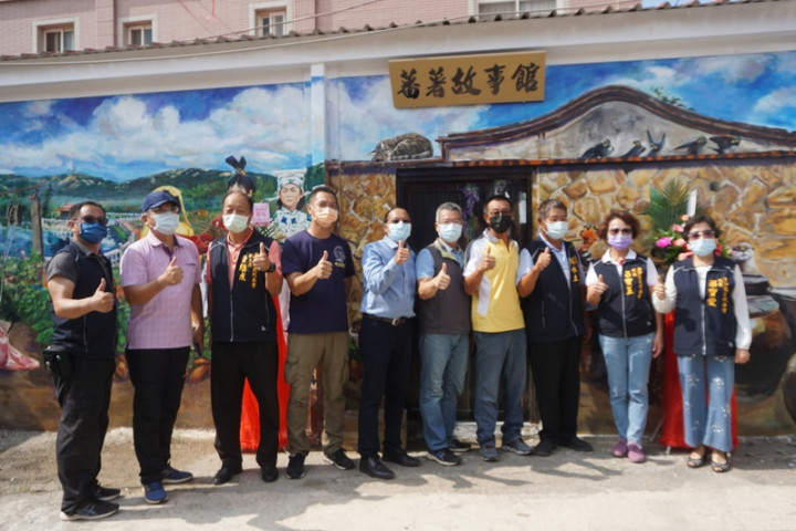 金門首屆駐縣藝術家鄒佳哲（左5）重返舊地，為何厝社區彩繪「番薯故事館」壁畫，27日舉行揭幕儀式；金沙鎮長吳有家（右5）等人出席共同見證。