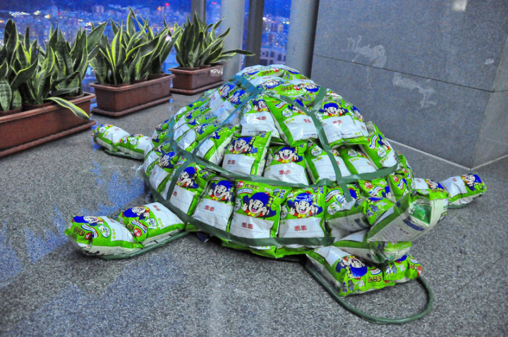 新北市政府水利局今年中元普渡以90包綠色「乖乖」製 作平安龜祭拜，取代常見的「麵龜」，目前放在水利局 入口處，盼風調雨順，天氣乖乖。