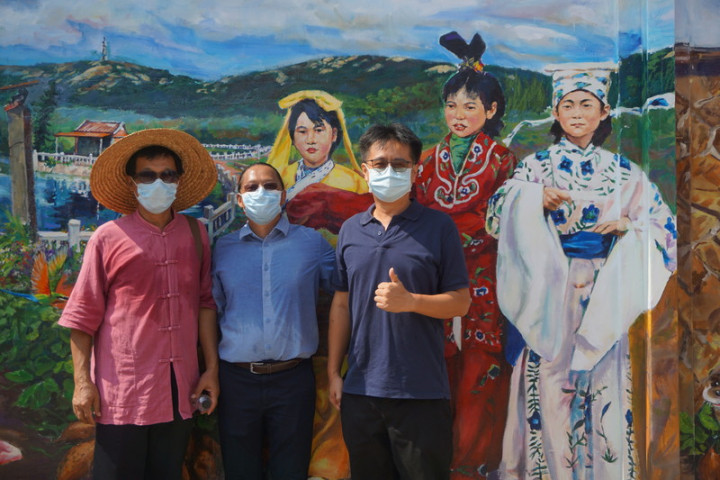 金門首屆駐縣藝術家鄒佳哲（中）重返舊地，為何厝社區彩繪壁畫，27日揭幕。他感謝前金門文化局長呂坤和（左），讓他得以體驗金門快樂的生活，進而愛上金門。