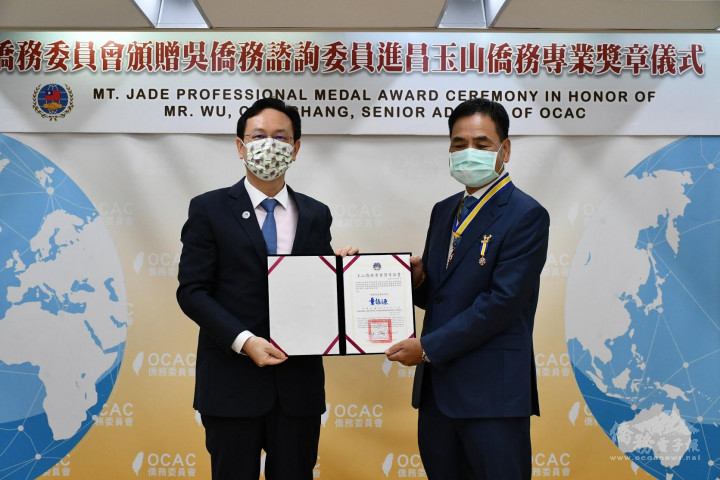 童振源(左)頒贈玉山僑務專業獎章給吳進昌(右)