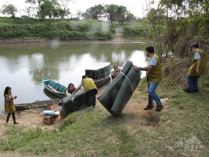 慈濟亞松森志工們將民生物資及兒童節禮品，搬運至簡易筏舟上，透過渡河的方式運送至伊皮卡島。