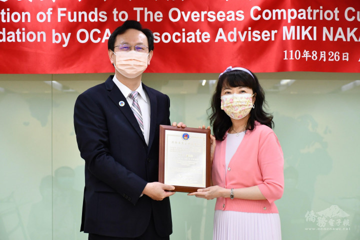 童振源(左)頒贈獎牌感謝中西美姬(右)長期的善行義舉