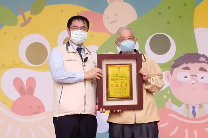 台南市麻豆區民詹評仁（右）從事台南文獻蒐錄近60年，獲台南市政府提報為卓越市民，5日由市長黃偉哲（左）頒發匾額致賀。