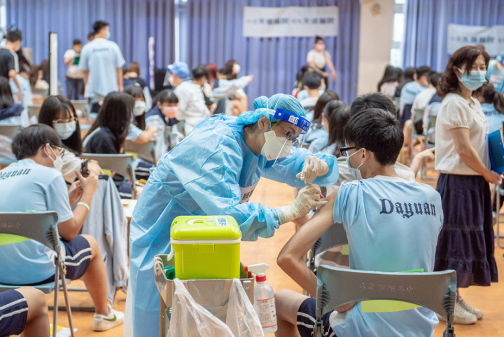 22日開放校園接種BNT疫苗，考量年輕男性打第2劑BNT後，恐有罕見心肌炎，指揮中心將觀察4到6週再評估是否接種第2劑。圖為桃園市校園施打疫苗。