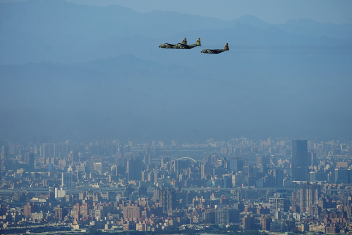 雙十國慶半兵力空中預演28日早晨在總統府前展開，國軍及空勤總隊共出動12型快、慢速機計29架飛越台北上空，圖為C-130運輸機飛往台北市區預演。