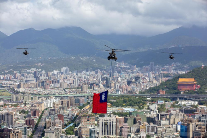 陸航空運作戰隊CH-47SD運輸直升機，吊掛巨幅國旗，在攻擊直升機的護衛下，飛越臺北上空。