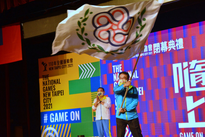110年全國運動會21日閉幕，新北市長侯友宜（左）將大會會旗交給下屆主辦城市台南市長黃偉哲（右）後，黃偉哲揮舞會旗，邀請大家到台南。