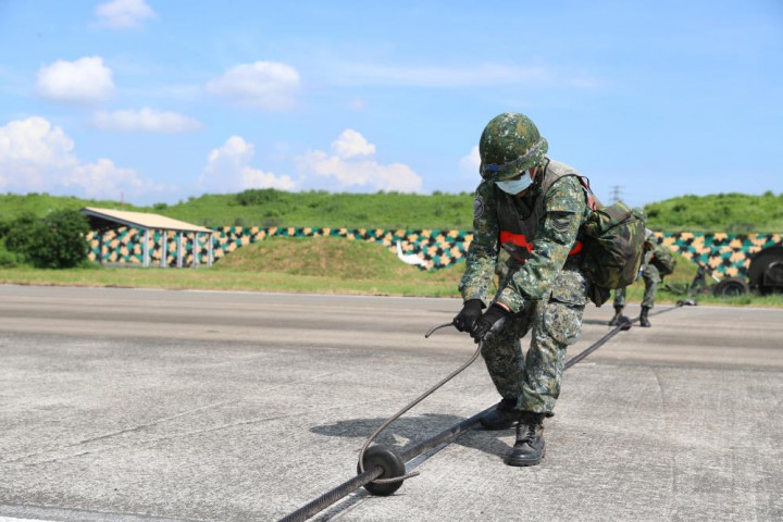 空軍第六聯隊官兵在屏東基地內演練機動攔機設施架設作業。