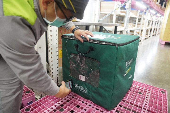 裕利醫藥因具備低溫冷鏈與全程即時控溫技術，成為台灣儲藏配送COVID-19疫苗的主要服務商。圖為配送人員用手機掃描保冷箱上的裝置，確認溫度與訂單相關資訊。