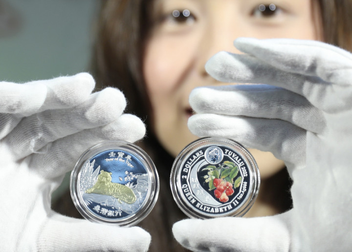 台灣銀行26日發行「壬寅虎年彩色鍍金精鑄銀幣」（圖），銀幣其中一面為老虎盤踞在象徵王座的岩台上，不怒而威的虎踞氣勢，另一面圖案取自台灣工筆畫大師張克齊的蓮霧畫作，象徵「好運連年」。