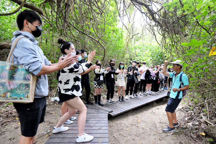 健行科技大學31日結合校內多國學生組成國際參訪團前往參與牽罟活動，環保志工介紹海岸旁的防風林，以及地方對在地文化的保護。