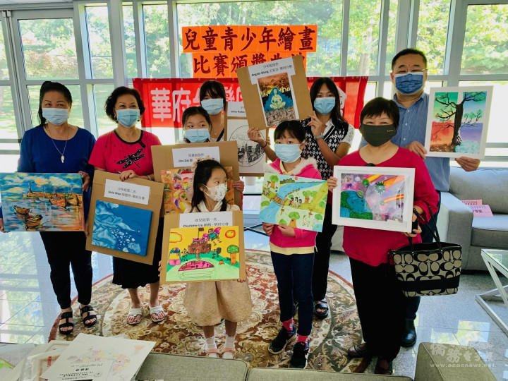 劉金萍會長（左2）及臺聯會工作人員與贏得全美畫賽入選作品的小朋友們合影