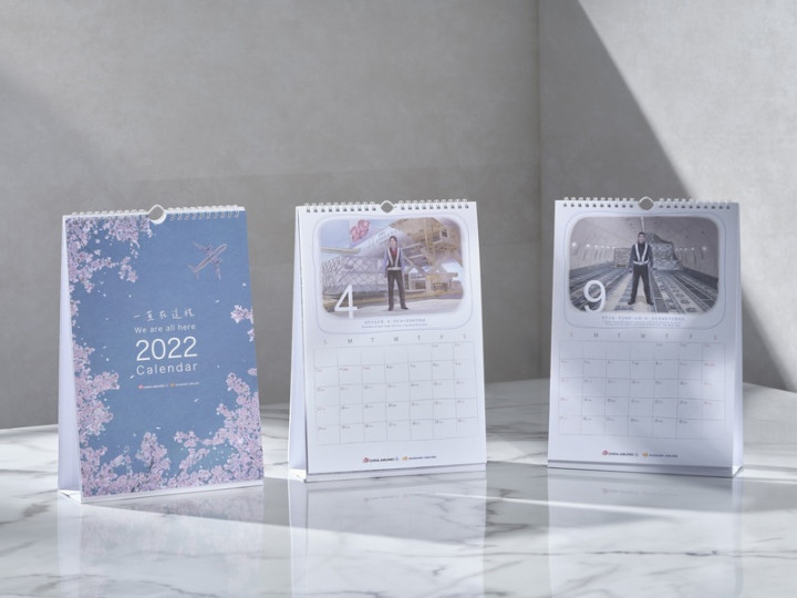 中華航空2022年月曆首次採用藝術插畫的文青風格，並創新結合掛曆與桌曆功能；月曆封面以獨特昂首的視角，抬頭仰望天空，鐵鳥展翅飛行於天際，為來年開啟美好世界的新面貌。（中華航空提供）
