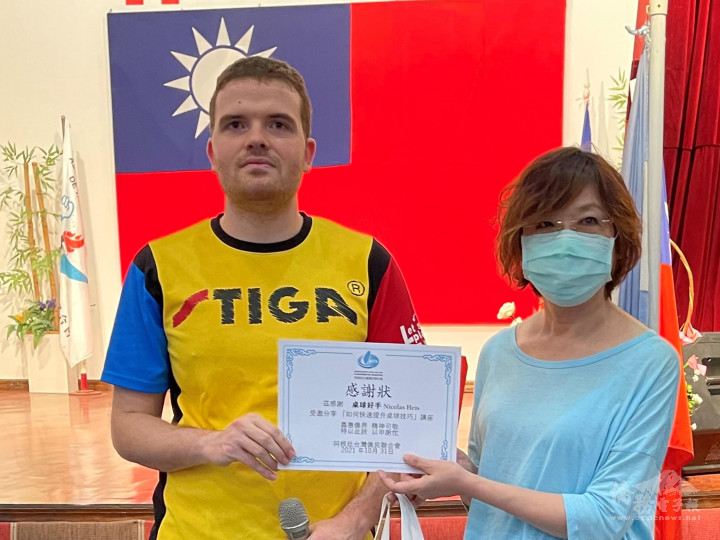 阿根廷臺灣僑民聯合會理事長(右)黃淑芳頒發感謝狀贈予桌球講師何恒慶(左) 