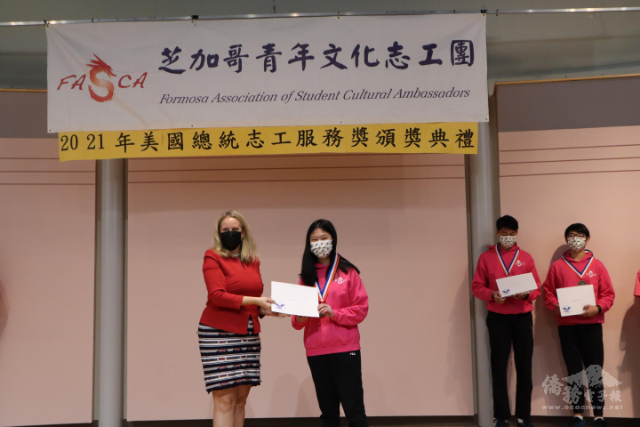 伊州眾議員Deanne Mazzochi為獲獎志工頒發獎章及獎狀