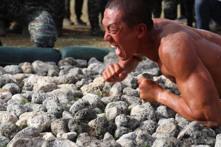 學員們以翻、滾、爬等動作在50公尺的咕咾石路上挺進。