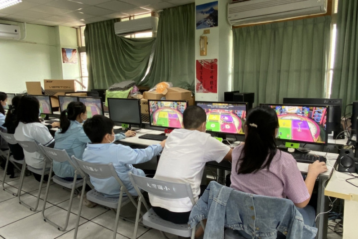 台南市政府教育局以遊戲概念打造幼兒園到高中的閱讀理解平台「布可星球」，29日在永康區大灣國小舉辦「布可星球小哲學堂擂台賽」，參賽學生專心在線上答題。（台南市政府提供）