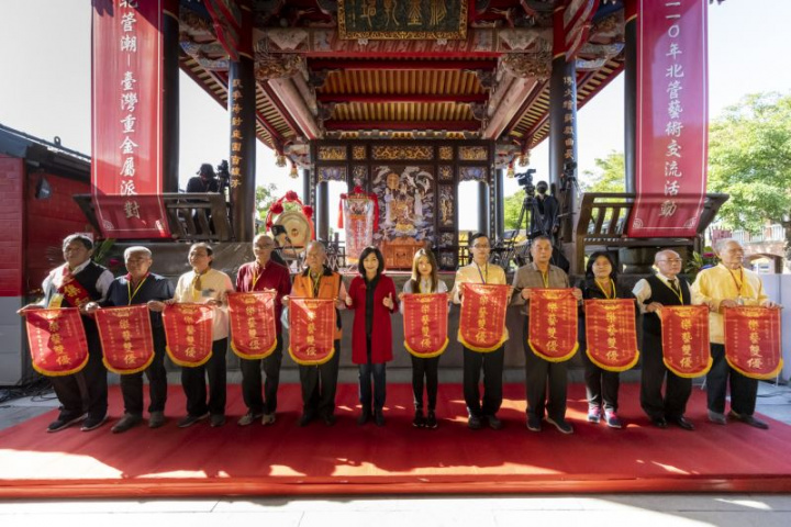 傳藝中心主任陳悅宜致贈紀念旗給參與開幕綵街活動的11組子弟軒社代表，感謝他們的熱情支持。